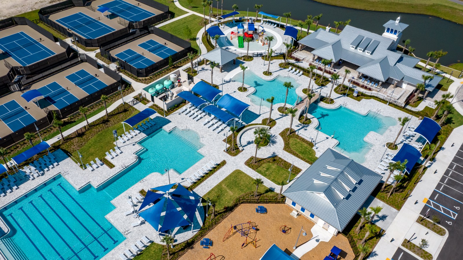 Aerial view of the SilverLeaf amenity center with pools, sports courts, playgrounds, and water